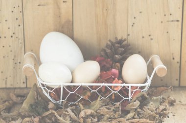 ahşap arka plan ile bir sepet içinde paskalya yumurtaları, vintage filtreli Görüntüler