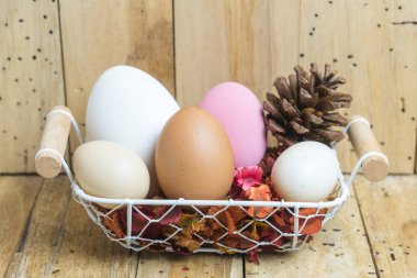 Paskalya yumurtaları tahta arka plan ile sepet içinde
