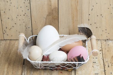 Paskalya yumurtaları tahta arka plan ile sepet içinde