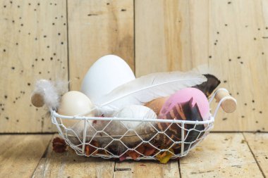 Paskalya yumurtaları tahta arka plan ile sepet içinde