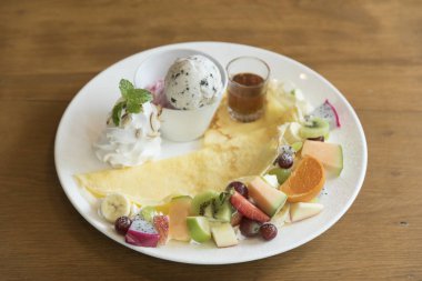 ahşap tahta üzerinde kivi ve ananas dilimleri ve krem ile crape kek.