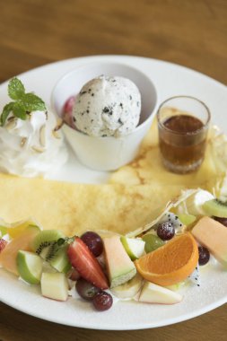 ahşap tahta üzerinde kivi ve ananas dilimleri ve krem ile crape kek.