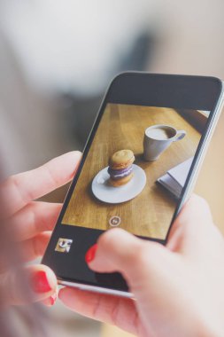 Fransızca macarons plaka ve bir fincan kahve, yumuşak odak arka plan üzerinde renkli