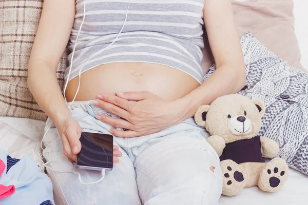 Zwangere Vrouw Met Een Teddybeer Diverse Kleding Voor Een Pasgeborene — Stockfoto
