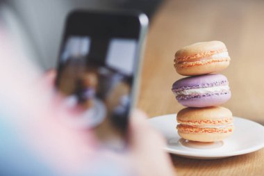 Fransızca macarons plaka ve bir fincan kahve, yumuşak odak arka plan üzerinde renkli