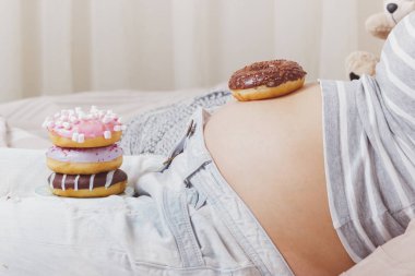 Plaka, yumuşak odak arka plan üzerinde farklı çörek ile hamile kadın