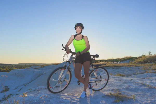 Young beautiful woman with a sport bike on a blue sky background