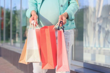 Kağıt paketleri Mall, yumuşak odak arka plan ile güzel bir hamile kadın