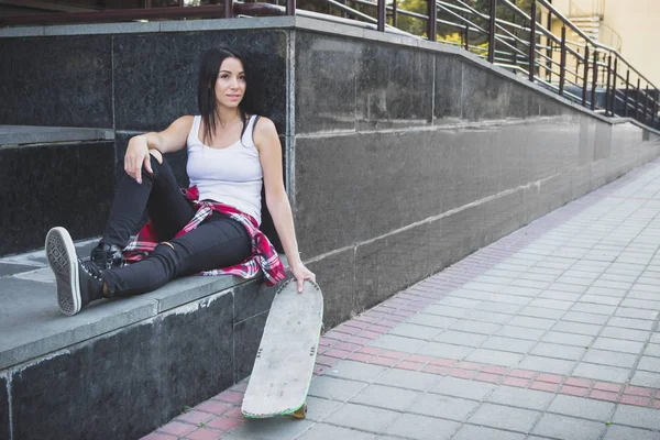 Bir kaykay üzerinde sokak, yumuşak odak arka plan ile güzel kadın