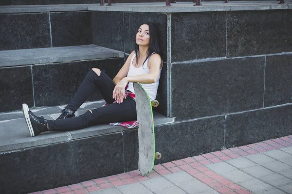 Bir kaykay üzerinde sokak, yumuşak odak arka plan ile güzel kadın