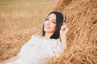 Kurutulmuş samanlık, yumuşak odak arka plan üzerinde güzel genç kadın