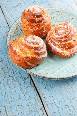 Mavi seramik tabak, açık ahşap renkli çörekler