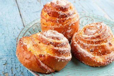 Mavi seramik tabak, açık ahşap renkli çörekler