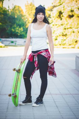 Bir kaykay üzerinde sokak, yumuşak odak arka plan ile güzel kadın