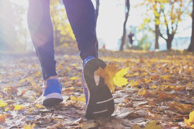 Sporcumuz mavi spor ayakkabı ve spor giyim, açık havada, yumuşak odak arka plan
