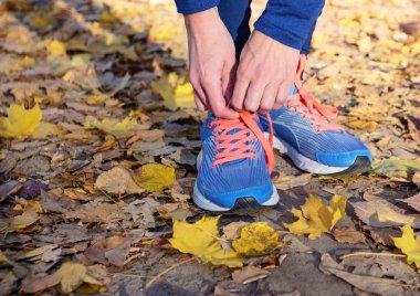 Sporcumuz mavi spor ayakkabı ve spor giyim, açık havada, yumuşak odak arka plan