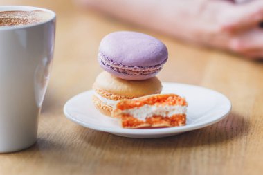 Fransızca macarons plaka ve bir fincan kahve, yumuşak odak arka plan üzerinde renkli