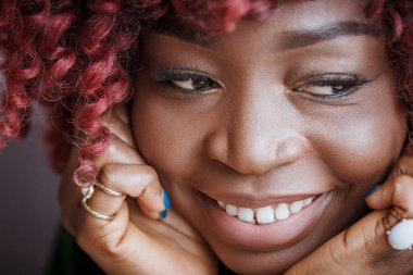 İnsanlar ve eğlence. Geri kalan kapalı olması, şirin dalgın gülümsemeyle, yumuşak odak arka plan seyir çekici genç Afrika kadın