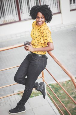 Kahve fincan sıcak içecek, holding rahat kıyafetler giymiş genç esmer kadının