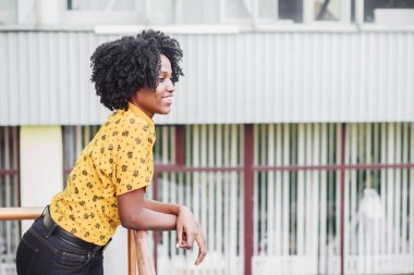 Esmer genç gülümseyen kadın rahat kıyafetler giymiş, arka plan bulanık