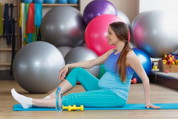 Donna Incinta Siede Sul Tappeto Palestra Con Una Bottiglia Acqua — Foto Stock