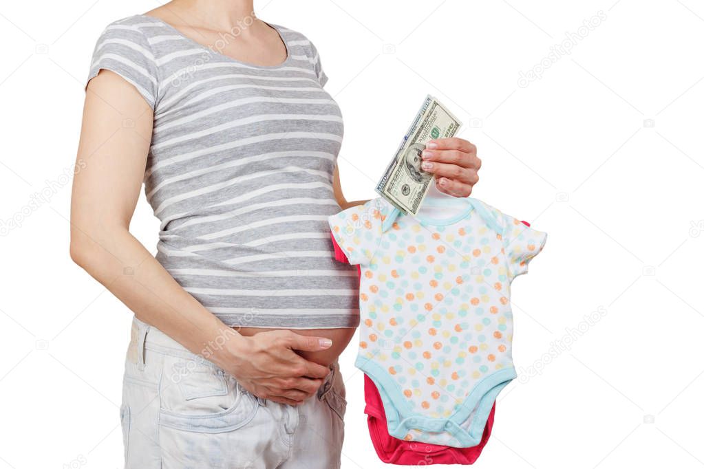 Pregnant woman with various colored clothes for a newborn and money in the hand, isolated on white background