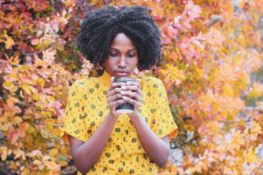 Kahve fincan sıcak içecek, holding rahat kıyafetler giymiş genç esmer kadının