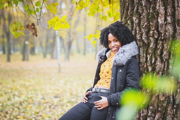 Young dark-skinned woman dressed in casual clothes, autumn