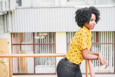 Esmer genç gülümseyen kadın rahat kıyafetler giymiş, arka plan bulanık