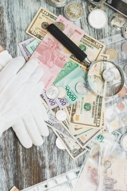 Elinde beyaz eldiven, farklı Amerikan Doları ve Endonezya JT, nümismatik kavramı, arka plan bulanık
