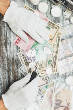 Elinde beyaz eldiven, farklı Amerikan Doları ve Endonezya JT, nümismatik kavramı, arka plan bulanık