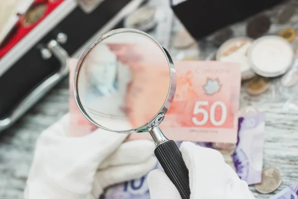 Manos en guantes blancos, diferentes dólares canadienses, concepto numismático — Foto de Stock