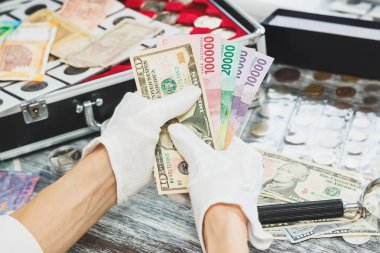 Elinde beyaz eldiven, farklı Amerikan Doları ve Endonezya JT, nümismatik kavramı