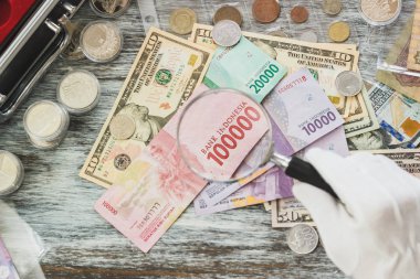 Elinde beyaz eldiven, farklı Amerikan Doları ve Endonezya JT, nümismatik kavramı