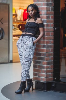 Alışveriş merkezinde rahat kıyafetler giymiş genç koyu tenli kadın