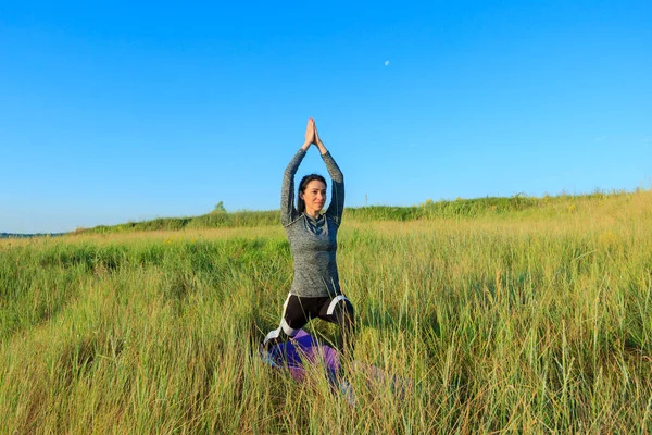 Mädchen in der Natur machen Yoga-Übungen für Fitness. — Stockfoto