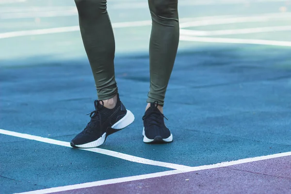 穿着运动鞋和运动服的女人在运动场上做运动练习,背景模糊 — 图库照片