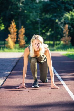 Güzel genç kadın spor zemin, bulanık arka plan üzerinde spor egzersizleri yapar