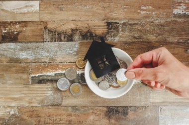 Altın ve gümüş sikkeler beyaz seramik tabakta Bir kadının ellerinde, üst manzara