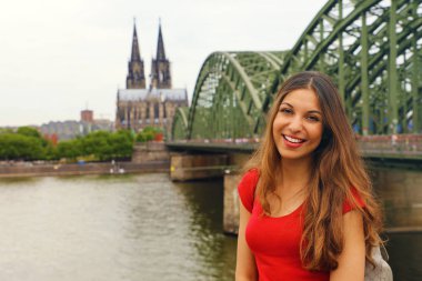 Onu seyahat Almanya'da zevk mutlu gülümseyen kadın. Köln Katedrali ve Ren Nehri üzerinde Hohenzollern köprü kamera önünde poz güzel gezgin kız.
