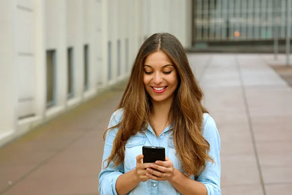 사무실 블록의 마당에 텍스트 메시지를 그녀의 Smartphone 장치에 프로그램을 — 스톡 사진