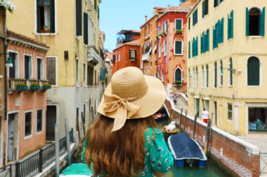 Hasır şapka Venedik renkli binaları köprüden canal, Venice, İtalya arıyor genç kadınla arkadan görünüm