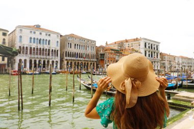 Venedik Grand Canal için ararken şapkasını tutarak Yeşil elbiseli olan kadın. Venedik, İtalya yolcusu kız arkadan görünüm.