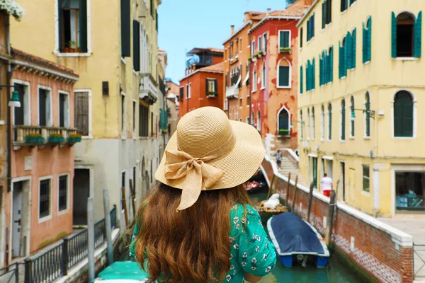 Hasır şapka Venedik renkli binaları köprüden canal, Venice, İtalya arıyor genç kadınla arkadan görünüm