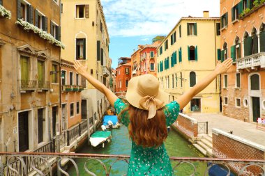 Europe seyahat tatil eğlenceli kadar kadın kolları olan yaz ve Venedik, İtalya'da mutlu bir şapka. Kaygısız kız turist Avrupa hedef yeşil moda elbise.