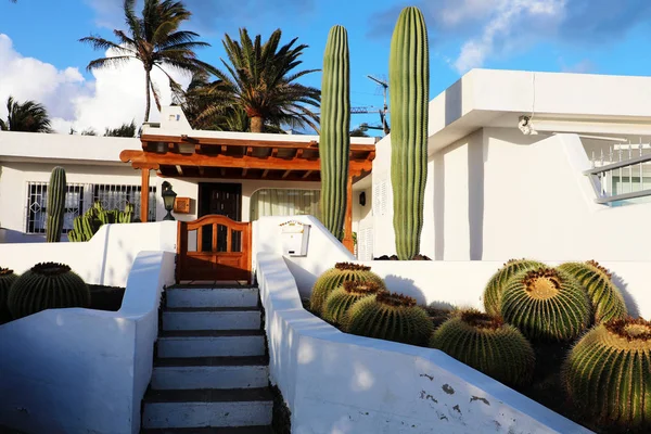 White modern house with cactus vegetation in Lanzarote Island, Spain. Summer vacation, travel destination, house rental concepts.