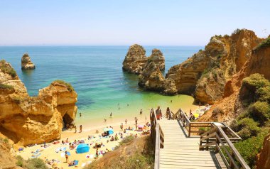 Lagos, Portekiz - 23 Haziran 2018: Camilo beach Lagos, Algarve, Portekiz yakınındaki yapmak insanlar Praia için ahşap merdiven tırmanma ile manzara şaşırtıcı
