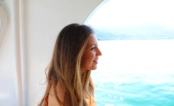 Cheerful young woman looking sea from ship. Cruise ship vacation woman enjoying her holiday on travel at sea.