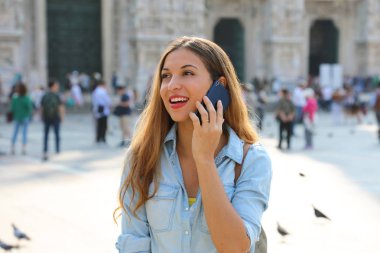 Çekici esmer iş kadını müşterisiyle cep telefonunda konuşuyor.