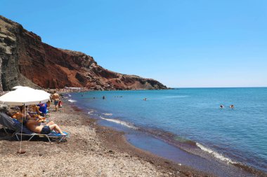 Satır şezlonglar ve şemsiyeler kırmızı Beach, Santorini, Yunanistan